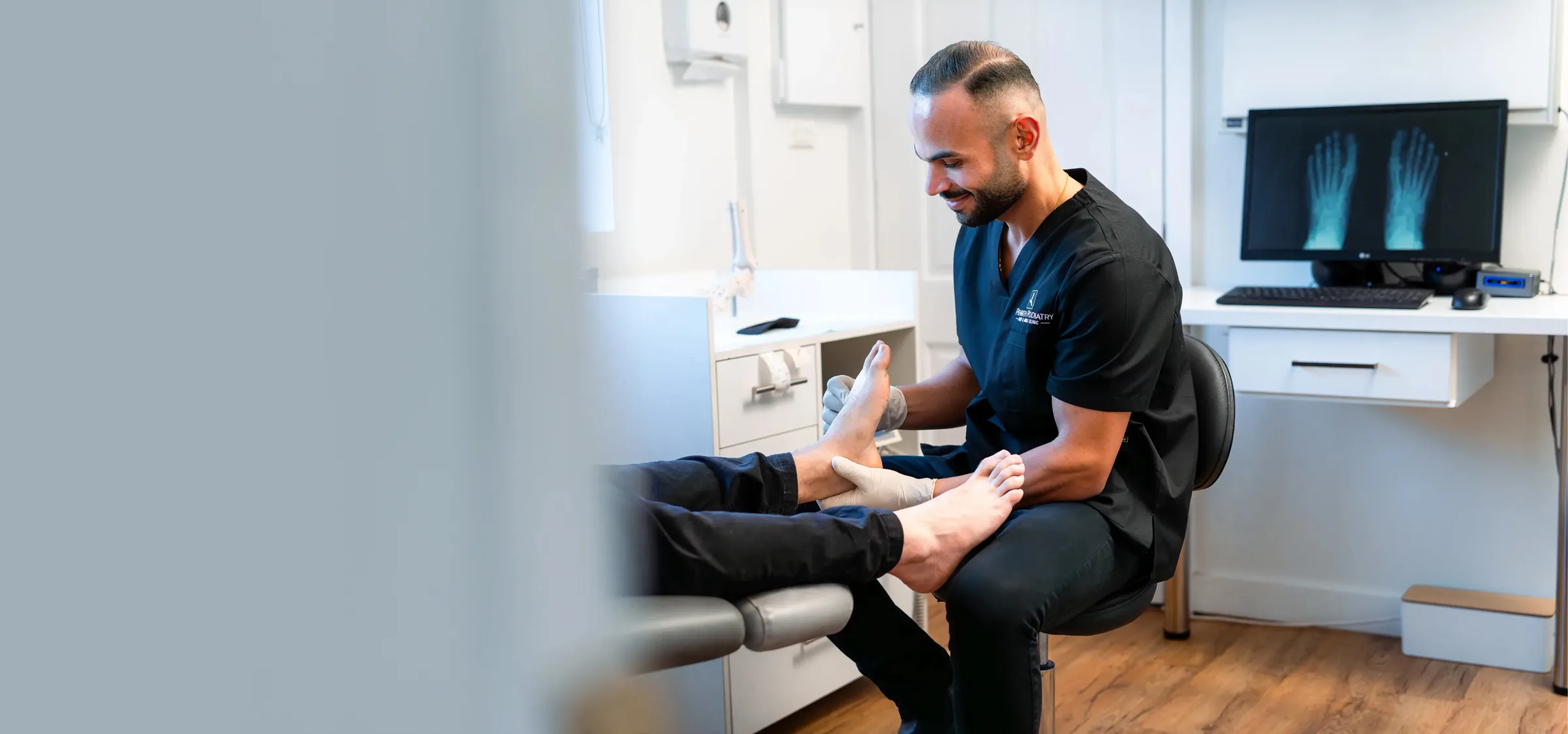 Penrith Podiatry Clinic podiatrist assessing a patient's foot with foot X-rays on screen