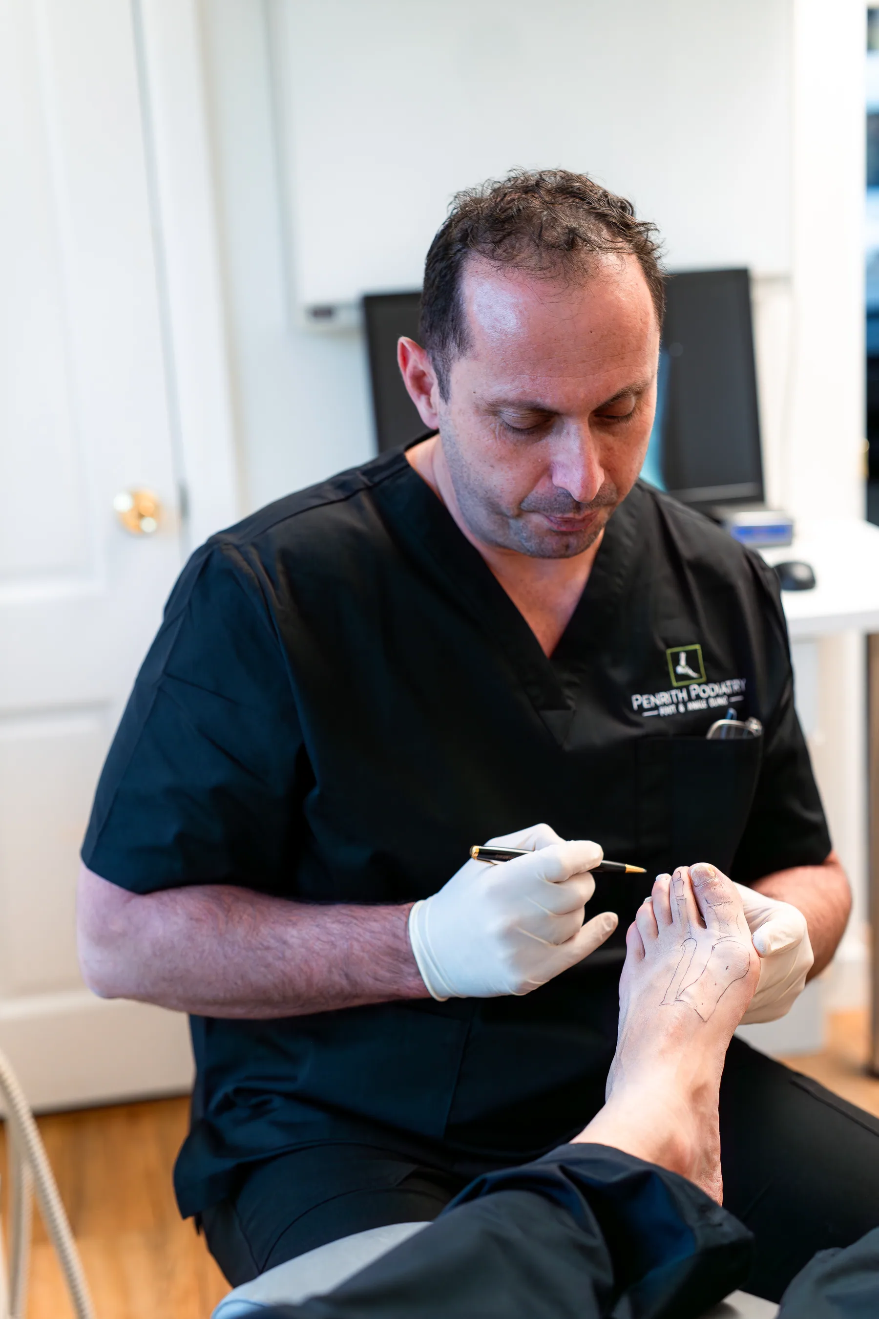 Podiatrist treating a patient's toenail at Penrith Podiatry Foot and Ankle Clinic